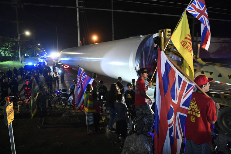 BRUCE ASATO / BASATO@STARADVERTISER.COM
                                The first of the wind farm parts left the Kalaeloa area early Thursday morning on its way to Kahuku as police officers on keep protesters away from the roadway.