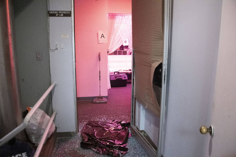 CRAIG T. KOJIMA /CKOJIMA@STARADVERTISER.COM
                                Law enforcement officials broke down the front door of a massage parlor at 320 Ward Avenue in Kakaako during a raid on July 29.