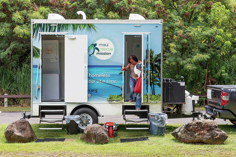 BRYAN BERKOWITZ / SPECIAL TO THE STAR-ADVERTISER
                                Ele Meyers exits after taking a shower at the mobile shower and laundry service provided by Maui Rescue Mission.