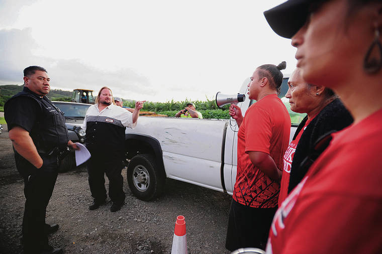 BRUCE ASATO / BASATO@STARADVERTISER.COM
                                Nakia Naeole, right with megaphone, related the view of the protesters Monday as several pieces of heavy equipment and trucks were brought to the site of the protest off Kamehameha Highway.