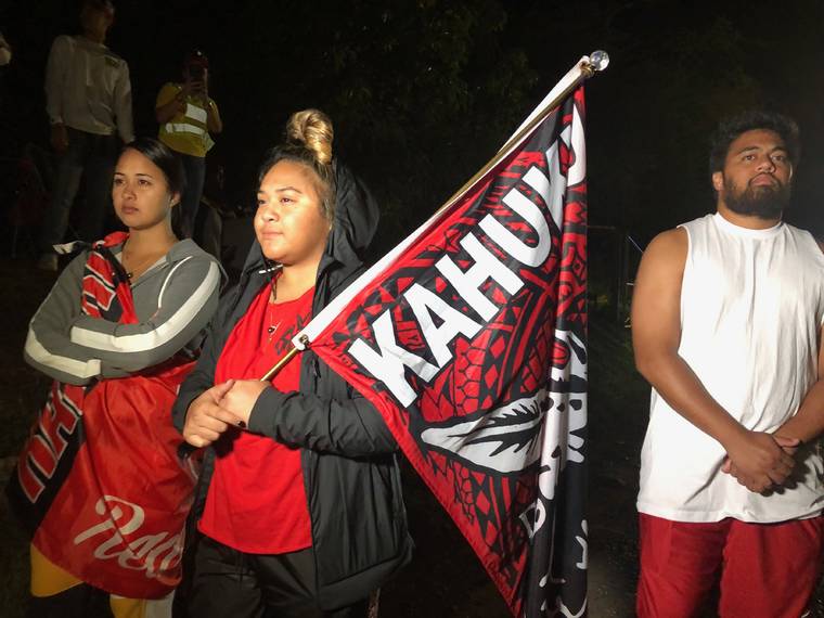 KAT WADE / SPECIAL TO THE STAR-ADVERTISER.
                                Jamaisha Farley, Iwalani Togiai Seei and Ammon Seei were among the protesters at Kalaeloa Monday night.