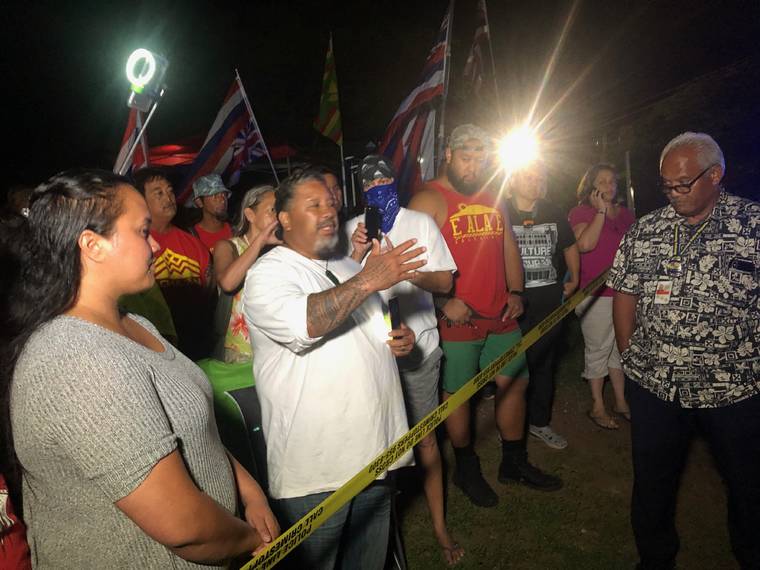 KAT WADE / SPECIAL TO THE STAR-ADVERTISER
                                Protestors against the Kahuku wind farm project gathered near Hanua and Malakole Streets in Kalaeloa Thursday night near the site of equipment that is expected to be moved to Kahuku.
