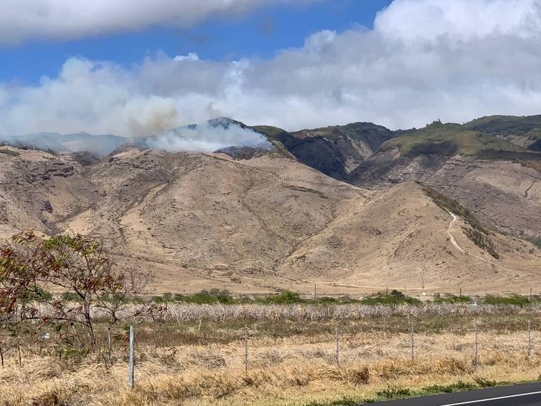 COURTESY MAUI FIRE DEPARTMENT
                                Maui firefighters are seen battling a brush fire on the upper slopes of the mountain near the intersection of N. Kihei Road and Honoapiilani Highway earlier today.