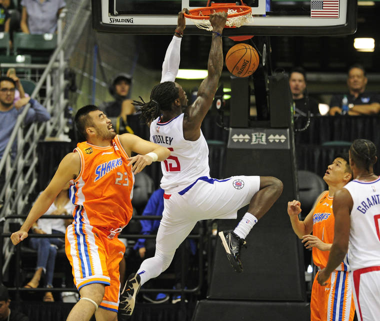BRUCE ASATO / BASATO@STARADVERTISER.COM
                                Los Angeles Clippers power forward Johnathan Motley finishes a dunk in front of Shanghai Sharks center Zhang Zhaoxu in the fourth quarter.