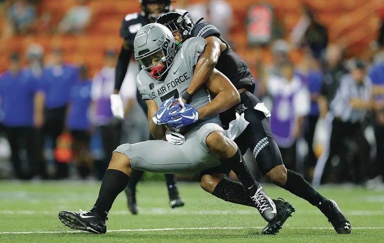 JAMM AQUINO / JAQUINO@STARADVERTISER.COM
                                Hawaii defensive back Zach Wilson wrapped up Air Force wide receiver Geraud Sanders during the first half of Saturday’s game at Aloha Stadium. Sanders finished with 116 yards and a touchdown in three receptions.