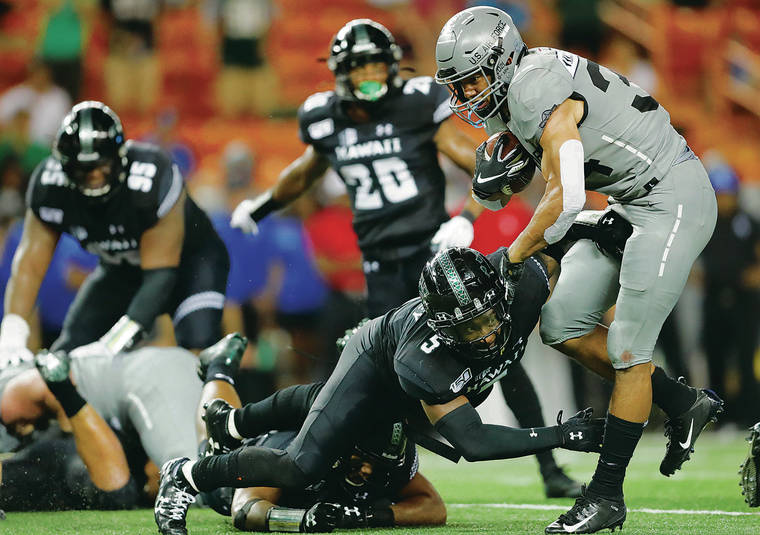 JAMM AQUINO / JAQUINO@STARADVERTISER.COM
                                Air Force fullback Timothy Jackson bounced off a hit by Hawaii defensive back Khoury Bethley (5) and linebacker Darius Muasau on his way to a 10-yard touchdown run during the third quarter of Saturday’s game at Aloha Stadium. Jackson finished with 113 rushing yards in the Falcons’ win.
