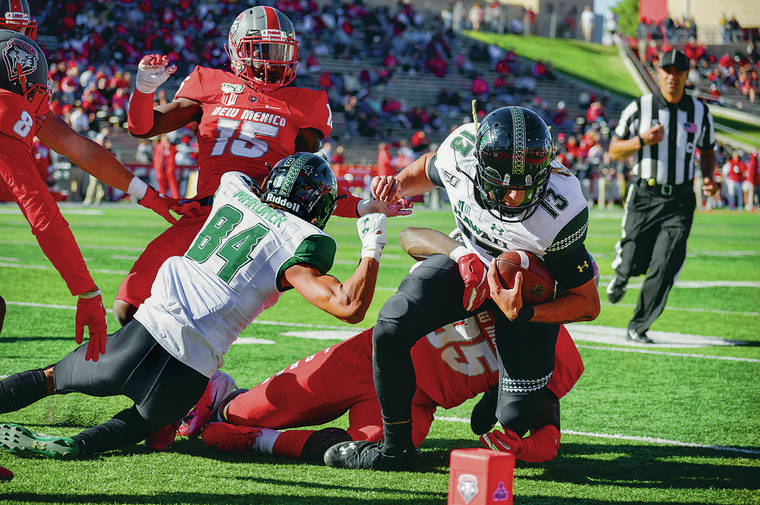 ANTHONY JACKSON / SPECIAL TO THE STAR-ADVERTISER
                                Hawaii quarterback Cole McDonald drove toward the end zone during Saturday’s game in Albuquerque, N.M. McDonald finished with 140 rushing yards and two touchdowns.
