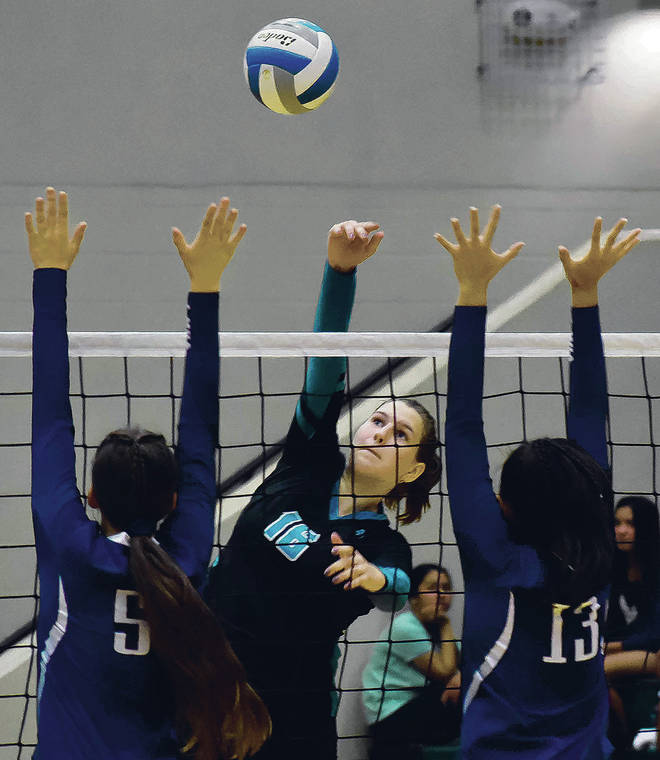RODNEY S. YAP / SPECIAL TO THE STAR-ADVERTISER
                                Senior outside hitter Eva Rueter spiked a kill between the Kamehameha block. Na Ali‘i beat the Warriors in five sets and is headed to the state championship tournament this month in Honolulu.