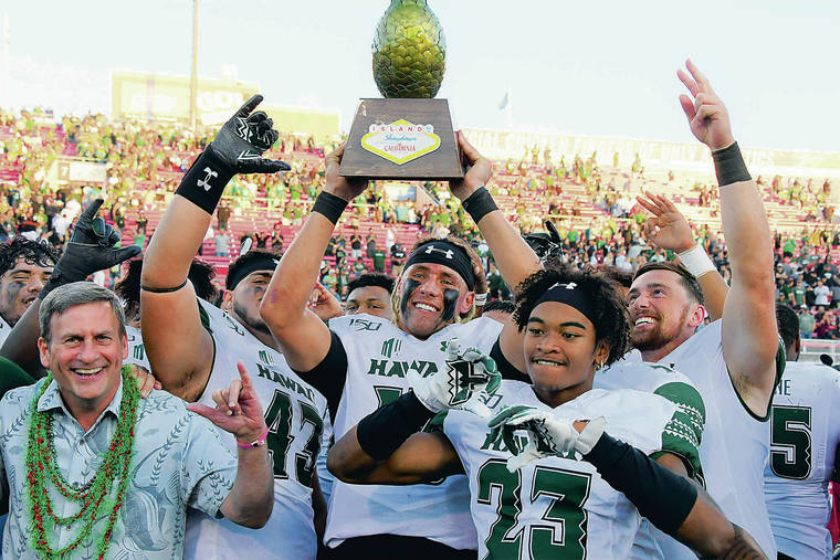 STEVEN ERLER / SPECIAL TO THE STAR-ADVERTISER
                                Hawaii quarterback Cole McDonald, middle, lifted the Island Showdown Trophy following Saturday’s win over UNLV. McDonald came off the bench and scored two rushing touchdowns.