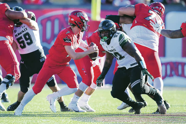 STEVEN ERLER / SPECIAL TO THE STAR-ADVERTISER
                                Hawaii defensive lineman DJuan Matthews, right, pressured UNLV quarterback Kenyon Oblad during the second half of Saturday’s game in Las Vegas. The Rainbow Warriors held the Rebels to 235 yards of total offense in a 21-7 win.