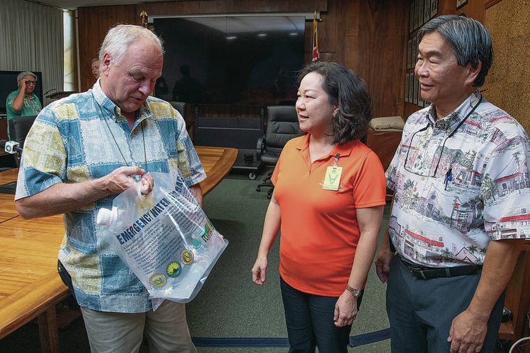 CRAIG T. KOJIMA /CKOJIMA@STARADVERTISER.COM
                                Kevin Richards of HI-EMA, left, showed the collapsible water jugs to be used during disasters with Rona Fukumoto, president and CEO of Lanakila Pacific, and Ernest Y.W. Lau, manager and chief engineer of the Board of Water Supply.