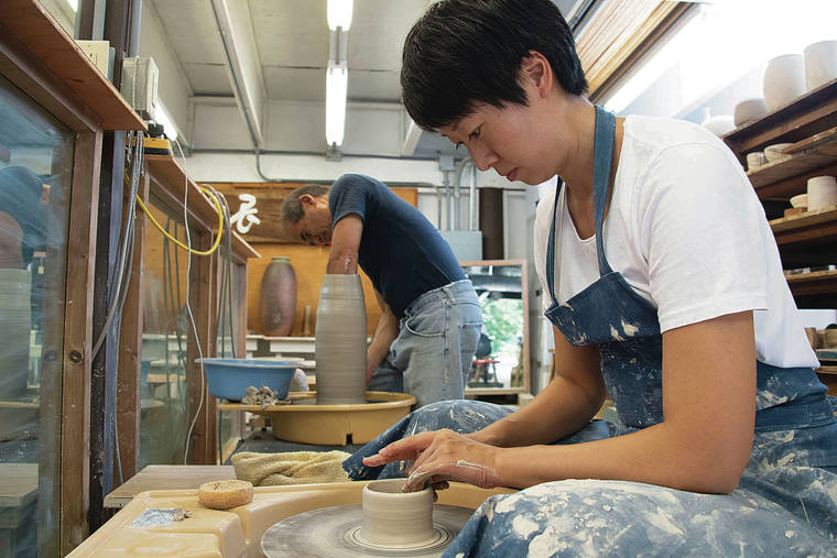 CRAIG T. KOJIMA / CKOJIMA@STARADVERTISER.COM
                                Ceramics students at Chozen-ji must face a mirror while using the pottery wheel, a practice that ensures their posture is upright and strong. Daijo Kaneshiro works on a large cylindrical piece and Cristina Moon throws a shallow bowl.