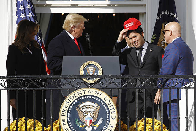 ASSOCIATED PRESS
                                Washington Nationals catcher Kurt Suzuki, second from right, puts on a MAGA hat as he walks past President Donald Trump and first lady Melania Trump to a podium to speak during an event to honor the 2019 World Series champion Nationals at the White House, today in Washington.