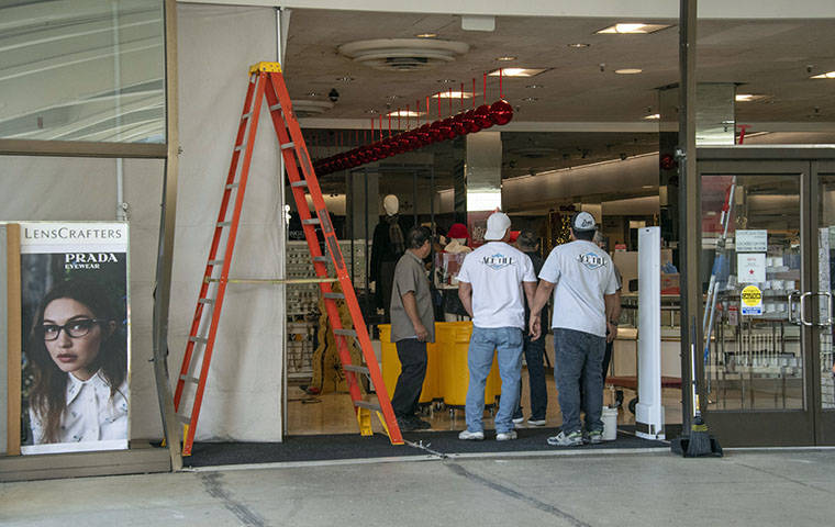 CRAIG T. KOJIMA / CKOJIMA@STARADVERTISER.COM
                                A repair crew sized up the hole left by a vehicle that rammed the store in an overnight burglary, today, at Ala Moana Center.