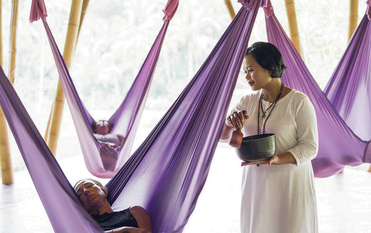 COURTESY FOUR SEASONS
                                Guests relax into aerial silk hammocks during a Sacred Nap at the Four Seasons Resort Bali at Sayan, Bali.
