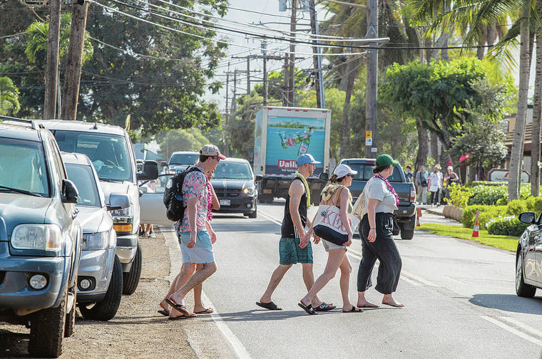 DENNIS ODA / DODA@STARADVERTISER.COM
                                Tourists crossed Kamehameha Highway in Haleiwa on Wednesday. October visitor arrivals numbers were up by 4.8% compared to the same time period the previous year.