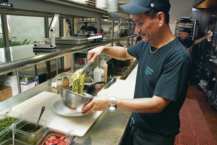 CRAIG T. KOJIMA / CKOJIMA@STARADVERTISER.COM
                                Chef Abes tosses noodles with pesto sauce in the cafe kitchen. The noodles are served with herbed roast chicken, a throwback dish from 2001.