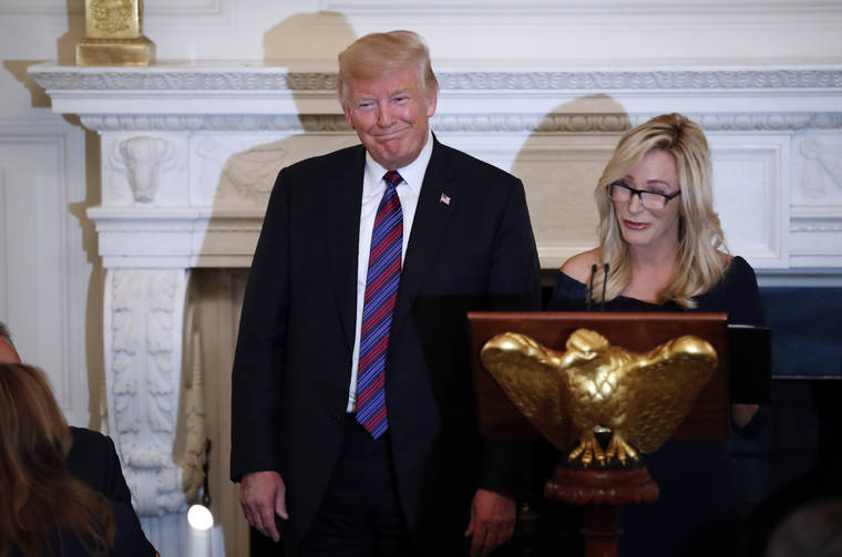 ASSOCIATED PRESS
                                President Donald Trump smiled as pastor Paula White prepared to lead the room in prayer, in Aug. 2018, during a dinner for evangelical leaders in the State Dining Room of the White House. White now has a formal role in the administration with the Public Liaison office.