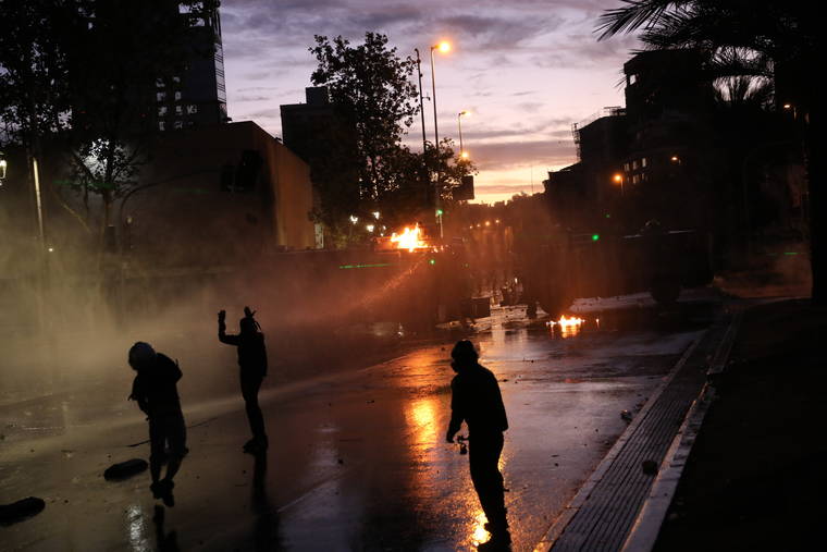ASSOCIATED PRESS
                                Anti-government protesters face off with a police water cannon in Santiago, Chile, today. Chile has been facing days of unrest, triggered by a relatively minor increase in subway fares. The protests have shaken a nation noted for economic stability over the past decades.