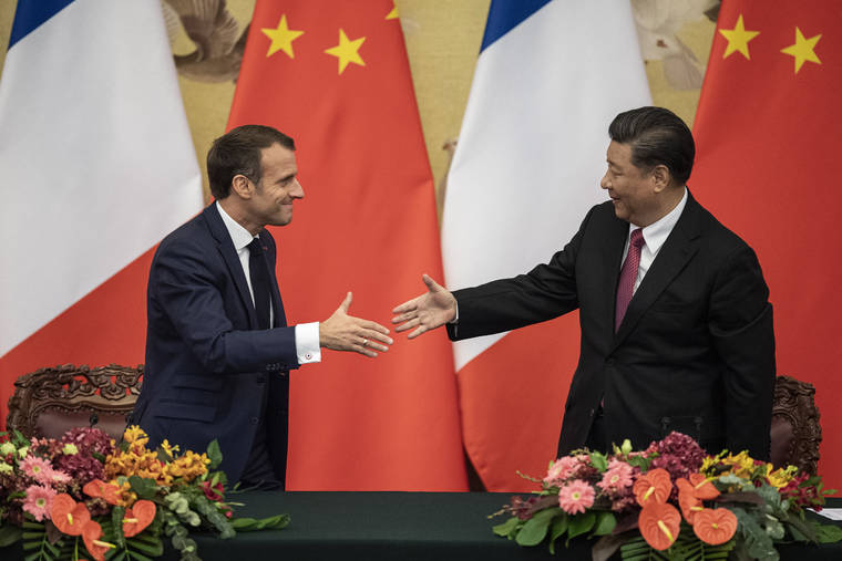 NICOLAS ASFOURI/POOL PHOTO VIA ASSOCIATED PRESS
                                French President Emmanuel Macron, left, shook hands with Chinese President Xi Jinping following a signing ceremony at the Great Hall of the People in Beijing, Wednesday.