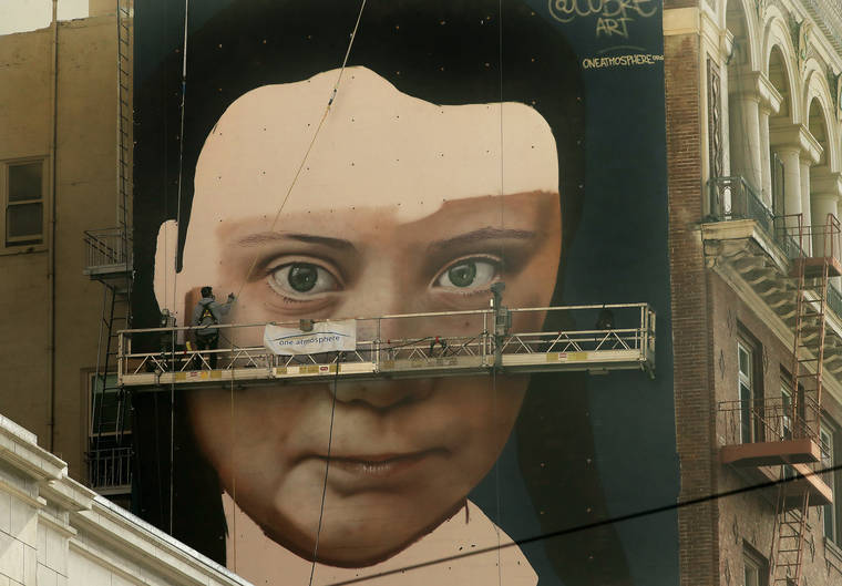 ASSOCIATED PRESS
                                Andres Petreselli paints a mural on the side of a building depicting Swedish teen climate activist Greta Thunberg in San Francisco.