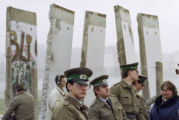 ASSOCIATED PRESS / 1989
                                East German border guards stand in front of segments of the Berlin Wall, which were removed to open the wall at Potsdamer Platz passage in Berlin. Months before the Berlin Wall fell on Nov. 9, 1989, with the Soviet stranglehold over the Eastern Bloc crumbling, a young political scientist named Francis Fukuyama made a declaration that quickly became famous. It was, he declared, “the end of history.”