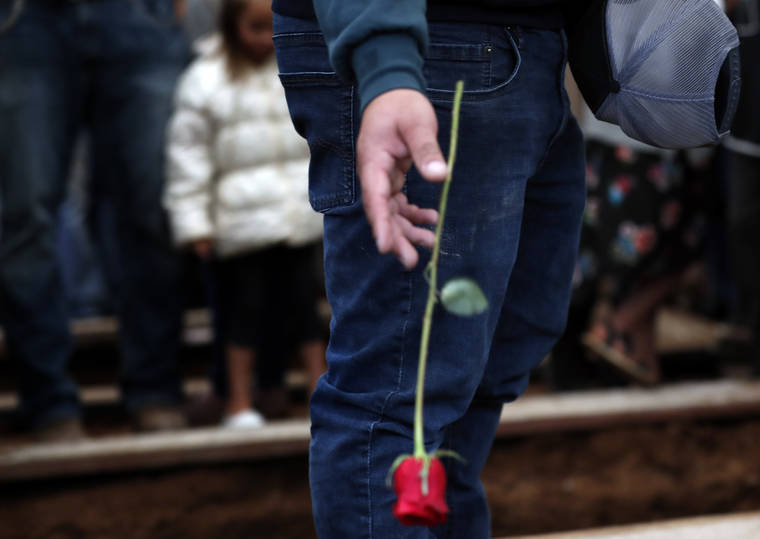 ASSOCIATED PRESS / NOV. 8
                                A mourner drops a red rose into a freshly dug grave at the cemetery in Colonia Le Baron, Mexico during the burial service for Rhonita Miller and four of her young children who were murdered by drug cartel gunmen. The bodies of Miller and four of her children were taken in a convoy of pickup trucks and SUVS, on the same dirt-and-rock mountainous road where they were killed Monday, for burial in the community of Colonia Le Baron in Chihuahua state.