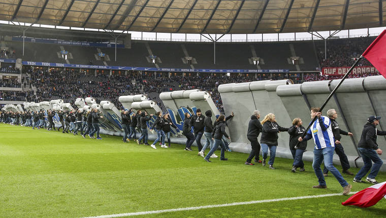 ANDREAS GORA/DPA VIA AP
                                Fans tear down a symbolic wall on the day of the 30th anniversary of the fall of the Berlin Wall prior the Bundesliga soccer match between Hertha BSC Berlin and RB Leipzig at the stadium in Berlin, Germany.
