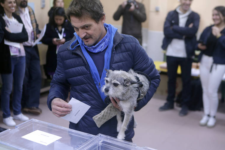 ASSOCIATED PRESS
                                A man holding a dog casts his vote for the general election in the outskirts of Madrid, Spain, today. Spain holds its second national election this year after Socialist leader Pedro Sanchez failed to win support for his government in a fractured Parliament.
