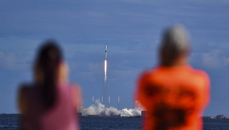 ASSOCIATED PRESS
                                Julie and Doc Todd watch the launch SpaceX from KARS Park in Florida today. SpaceX launched 60 mini satellites Monday, the second batch of an orbiting network meant to provide global internet coverage.