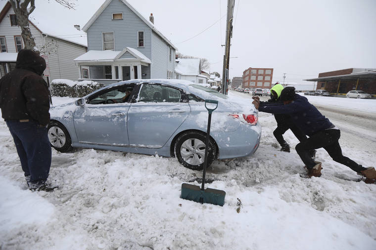 TINA MACINTYRE-YEE/ROCHESTER DEMOCRAT AND CHRONICLE VIA ASSOCIATED PRESS
                                Dwight Green stood aside as Coty Paige and Cornelius McCaley pushed a car that got stuck in the snow in Rochester, N.Y., today.