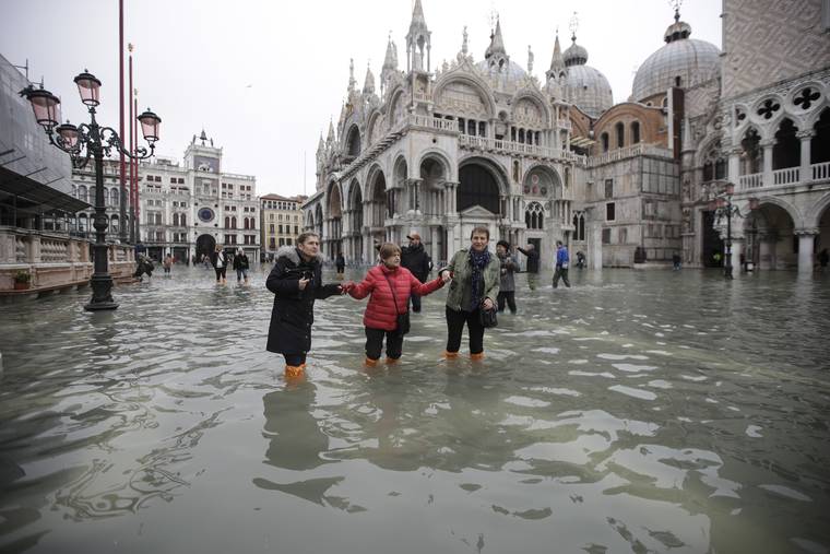 ASSOCIATED PRESS
                                People waded through water in a flooded St. Mark’s Square in Venice, Italy, today. The high-water mark hit 74 inches late Tuesday, meaning more than 85% of the city was flooded.