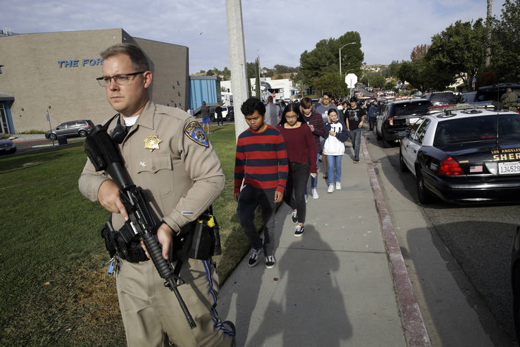 ASSOCIATED PRESS
                                Students were escorted out of Saugus High School after reports of a shooting, Thursday, in Santa Clarita, Calif.