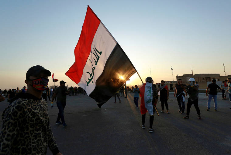 ASSOCIATED PRESS
                                People walk through Khilani Square after protesters took control and reopened it after clashes between Iraqi security forces and anti-government demonstrators in Baghdad, Iraq, on Saturday.