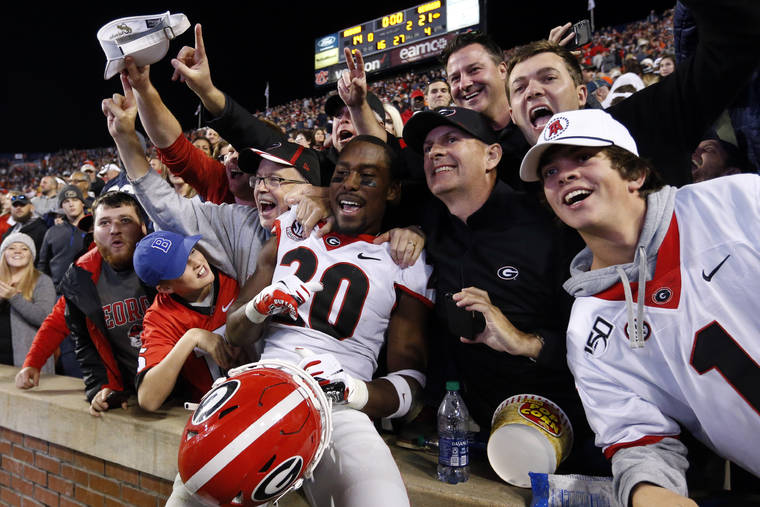 ASSOCIATED PRESS
                                Georgia defensive back J.R. Reed (20) celebrates with fans after the team defeated Auburn 21-14 in an NCAA college football game on Saturday in Auburn, Ala.