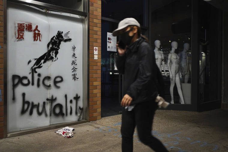 ASSOCIATED PRESS
                                A protester walks past graffiti depicting police as a dog and various slogans including “Hongkongers Resist, “Chinese Communist whole family die” at the Hong Kong Polytechnic University in Hong Kong on Wednesday.