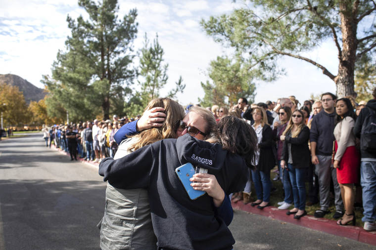 SARAH REINGEWIRTZ/THE ORANGE COUNTY REGISTER VIA AP
                                Students reunite with their families at Central Park following a shooting that injured several people at Saugus High School today in Santa Clarita, Calif.