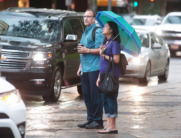 CRAIG T. KOJIMA / CKOJIMA@STARADVERTISER.COM
                                Walkers looked upward, possibly examining weather conditions, Tuesday while waiting to cross King Street.