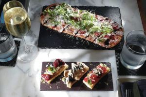 JAMM AQUINO / JAQUINO@STARADVERTISER.COM
                                The Duck Prosciutto Flat Bread, top, and the daily bruschetta special are two of the three $20 happy hour food specials, which include a glass of white, red or sparkling wine at Dean & DeLuca in Waikiki.