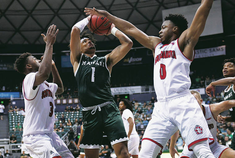 BRUCE ASATO / BASATO@STARADVERTISER.COM
                                Hawaii guard Drew Buggs put up a shot between South Dakota’s Triston Simpson, left, and Stanley Umude in the second half of Sunday’s game in the Outrigger Resorts Rainbow Classic at the Stan Sheriff Center.