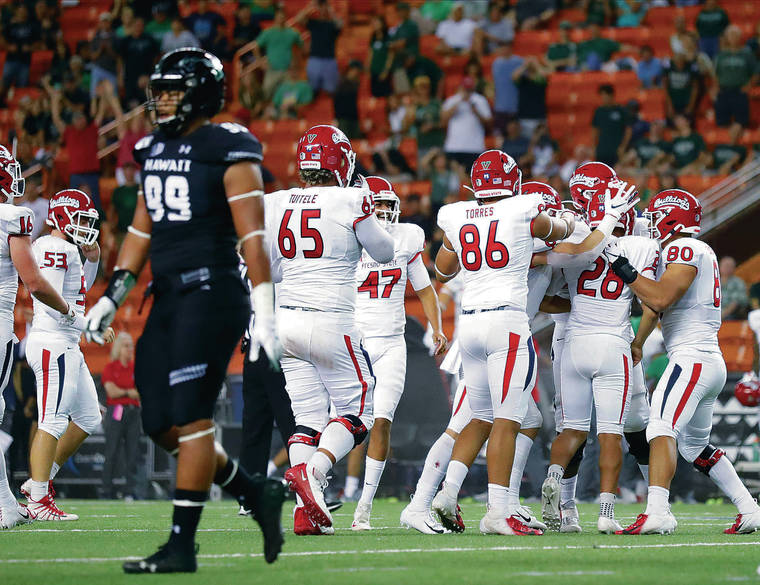 JAMM AQUINO / JAQUINO@STARADVERTISER.COM
                                Hawaii’s Jonah Laulu, left, walked off the field as Fresno State place-kicker Cesar Silva (28) celebrated with his teammates after kicking the last-second field goal to give the Bulldogs a 41-38 win over Hawaii on Saturday at Aloha Stadium.