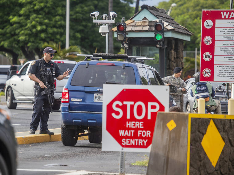 DENNIS ODA / DODA@STARADVERTISER.COM
                                Security personnel guard the Pearl Harbor main gate following reports of an active shooter situation on the naval base today.