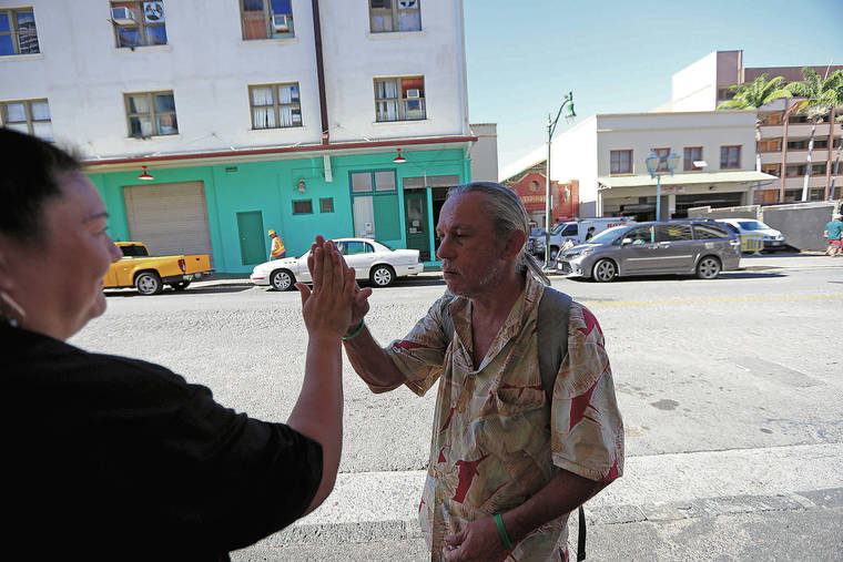JAMM AQUINO / JAQUINO@STARADVERTISER.COM
                                Jeffrey Chipman, 52, high-fived ‘Ohana Health Plan housing coordinator Jennifer Tehotu while walking along Pauahi Street in Honolulu last week.