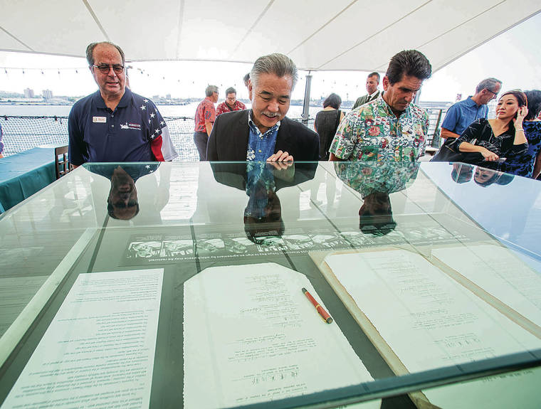DENNIS ODA / DODA@STARADVERTISER.COM
                                Mike Carr, left, president and CEO of the USS Missouri Memorial Association, Gov. David Ige and Steven W. Colon looked over the replicas of the papers Wednesday that were signed to end WWII.