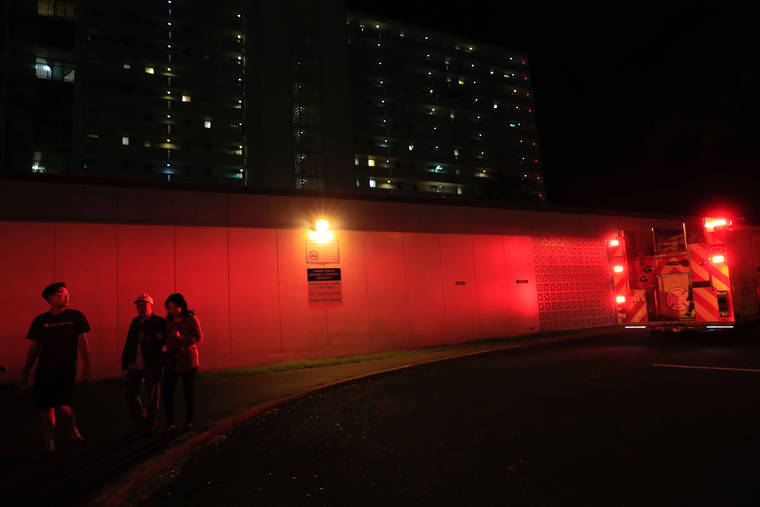 JAMM AQUINO / JAQUINO@STARADVERTISER.COM
                                Residents at 1220 Aala Street evacuate as firefighters contain a fire within the complex tonight.