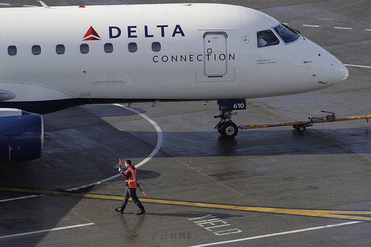 ASSOCIATED PRESS
                                In this Feb. 5, 2019, file photo a ramp worker guides a Delta Air Lines plane at Seattle-Tacoma International Airport in Seattle.