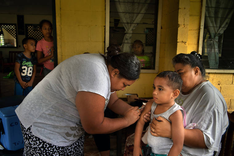 NEW YORK TIMES Johan Auvele, 3, is vaccinated by a Samoan health worker in Apia, Samoa, on Dec. 11. A measles epidemic has killed dozens of young children in the past two months and infected thousands more, leaving virtually no one in this nation of big families and communal living untouched.