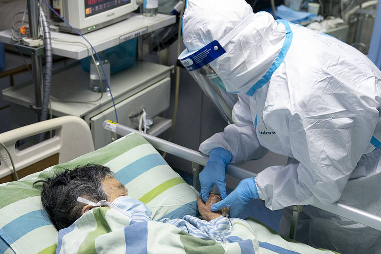 XINHUA VIA AP
                                In a photo released by China’s Xinhua News Agency, a medical worker attends to a patient in the intensive care unit at Zhongnan Hospital of Wuhan University in Wuhan in central China’s Hubei Province on Friday.