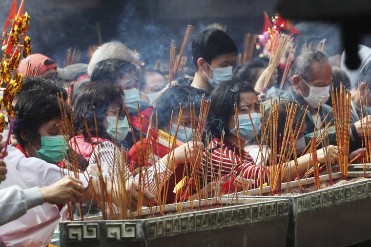 ASSOCIATED PRESS
                                People burn joss sticks as they pray at the Wong Tai Sin Temple, in Hong Kong, to celebrate the Lunar New Year which marks the Year of the Rat in the Chinese zodiac.