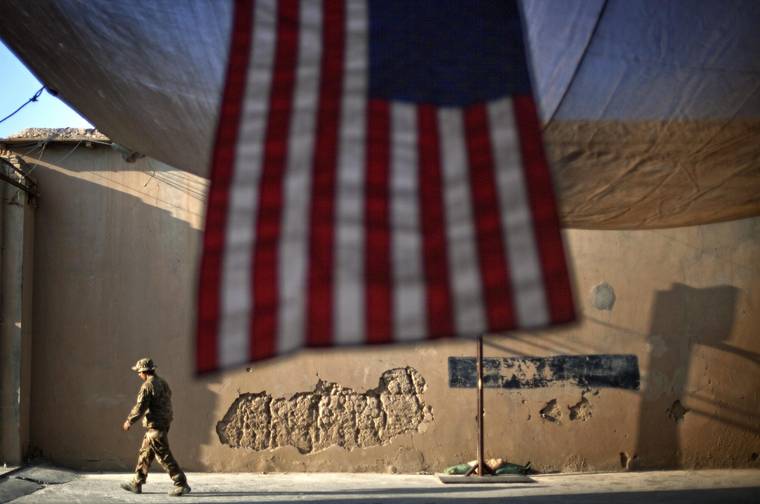 ASSOCIATED PRESS / 2011
                                A U.S. Army soldier with the 25th Infantry Division, 3rd Brigade Combat Team, 2nd Battalion 27th Infantry Regiment walks past an American Flag hanging in preparation for a ceremony commemorating the tenth anniversary of the 9/11 attacks, Sept. 11, 2011 at Forward Operating Base Bostick in Kunar province, Afghanistan. Most Afghans want US and NATO troops to leave Afghanistan once a peace deal to end Afghanistan’s 18-year war is signed with the Taliban, according to a survey carried out by the American Institute of War and Peace Studies. The survey conducted in 2019, between Nov. 23 and Dec. 20 has a five percent margin of error.